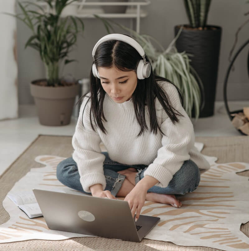 a girl sitting on the floor with a laptop